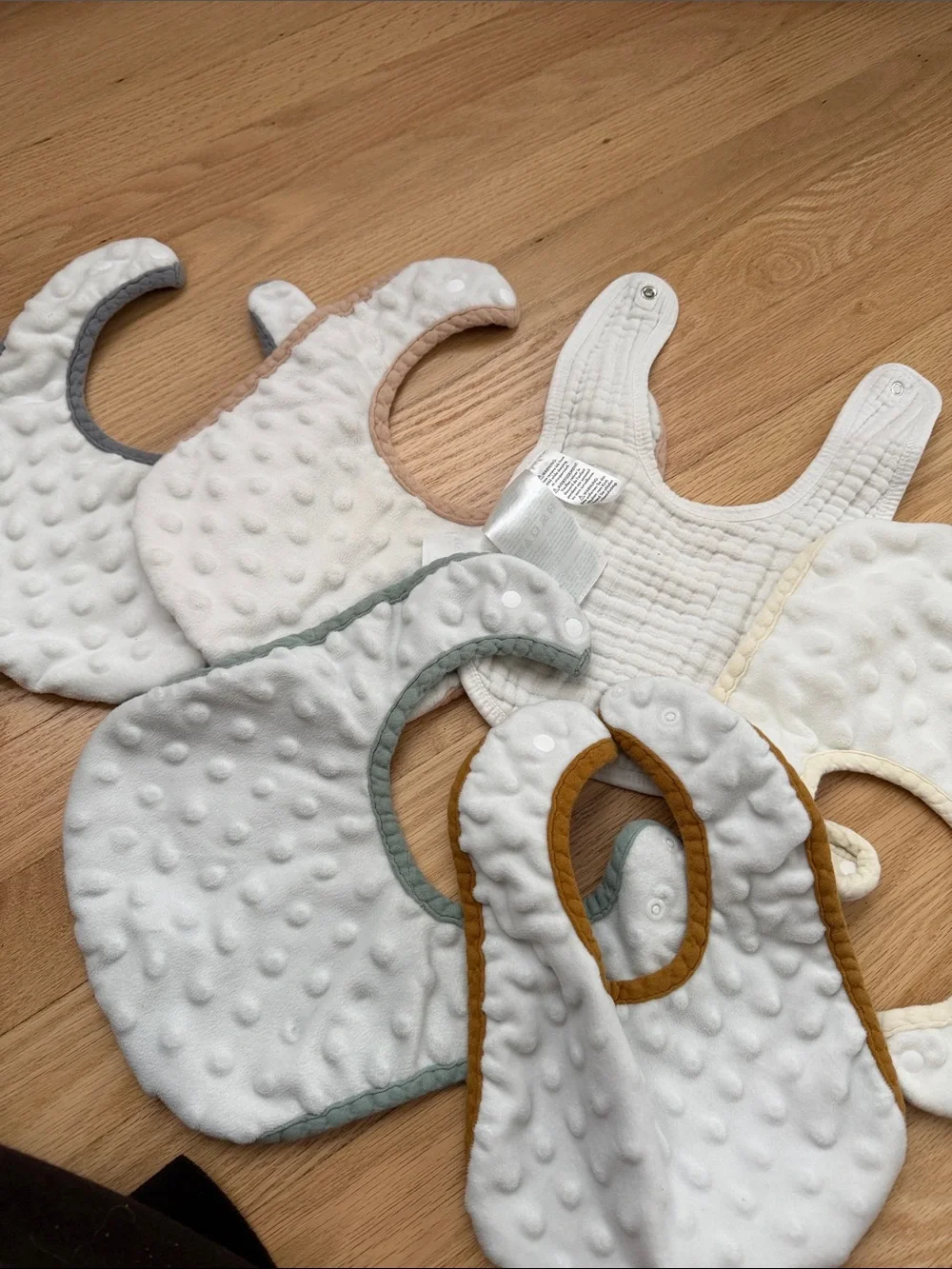 Bundle of muslin baby bibs in earthy colors
